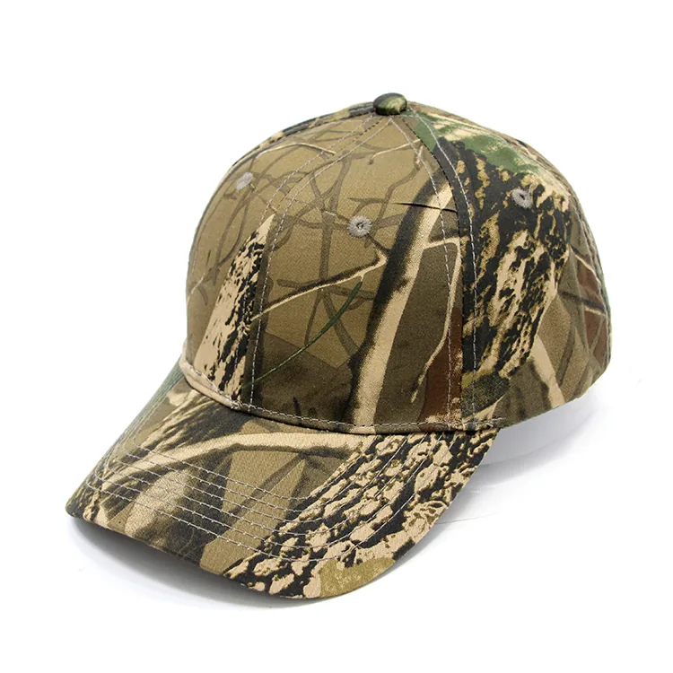 Three-quarter view of a tan and green curved-brim cap with dark woodland-style shapes across the crown and brim.