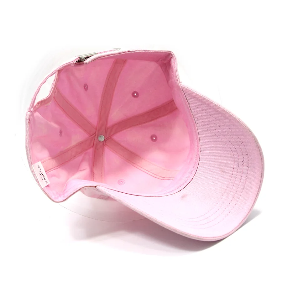 Inside view of a pink cap showing panel seams, seam covering, inner band and the underside of the brim.