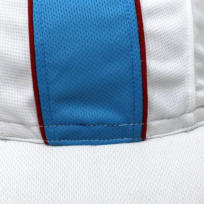 Detail crop from the same white cap photo showing the blue center area, red edges and their front meeting points above the brim.