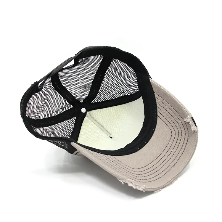 Inside view of a light-front and black-mesh trucker cap showing the underside of the front, mesh crown and dark edge band.