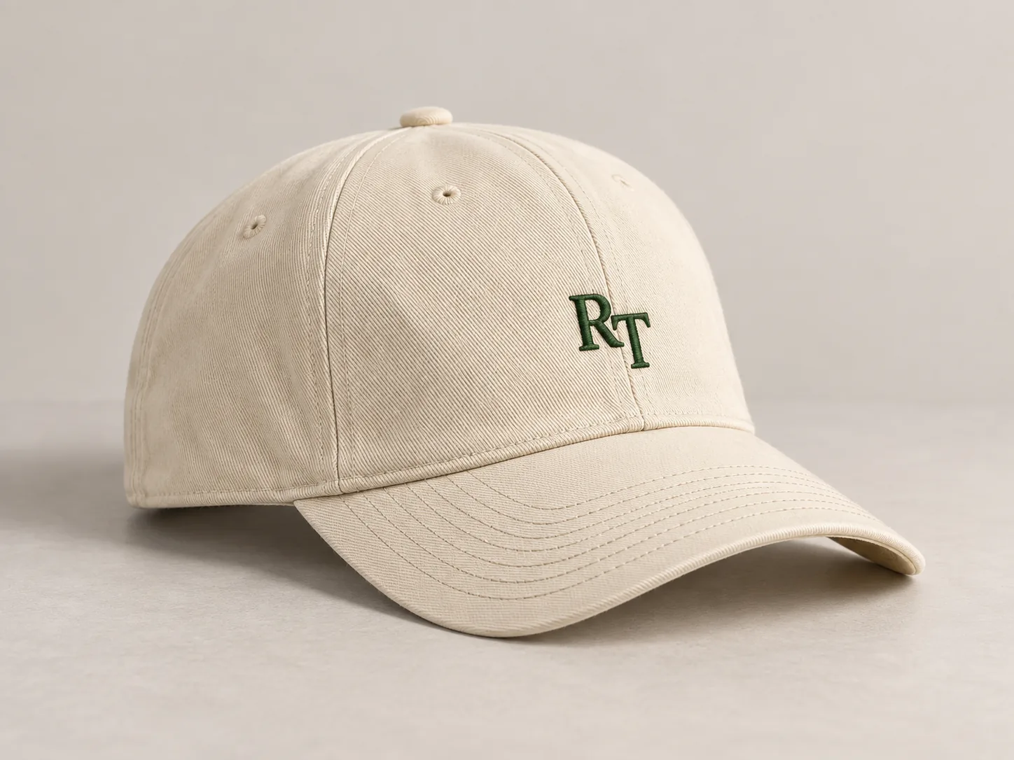 Illustrative cream custom cap with dark-green RT embroidery and a curved brim